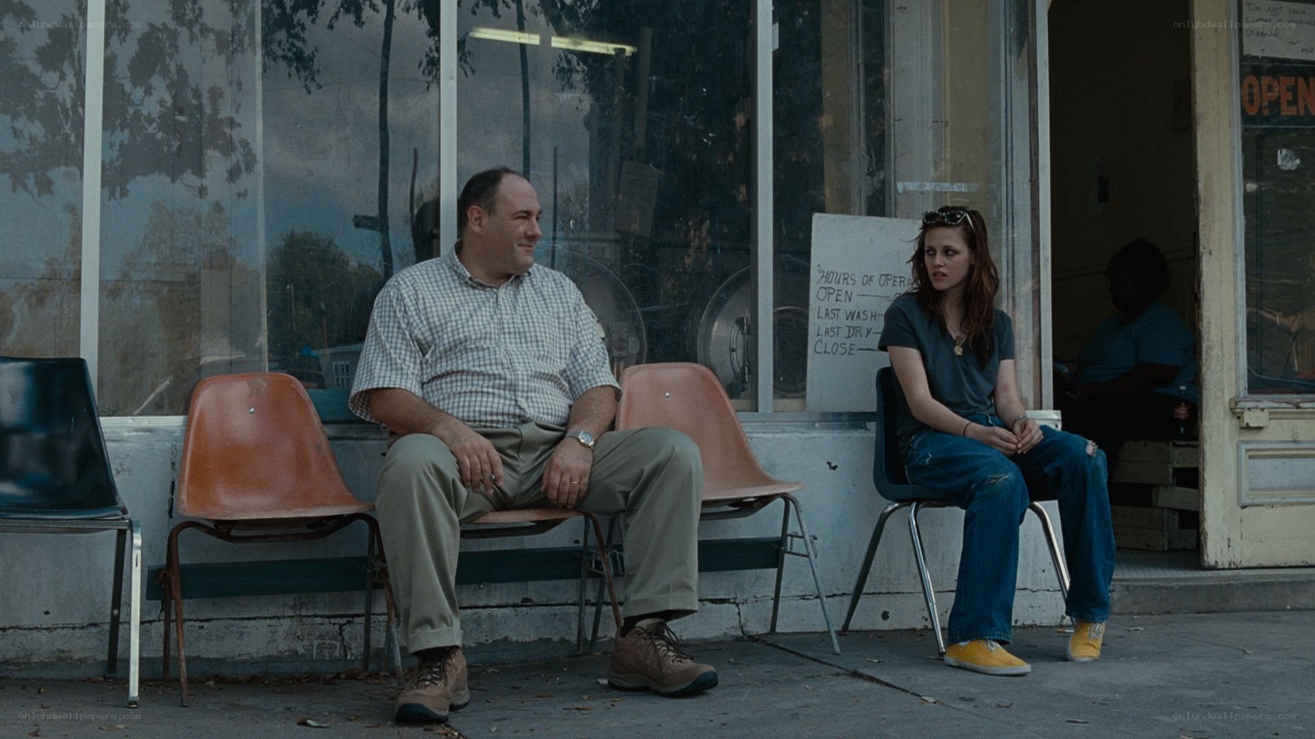 two people sitting outside a laundromat