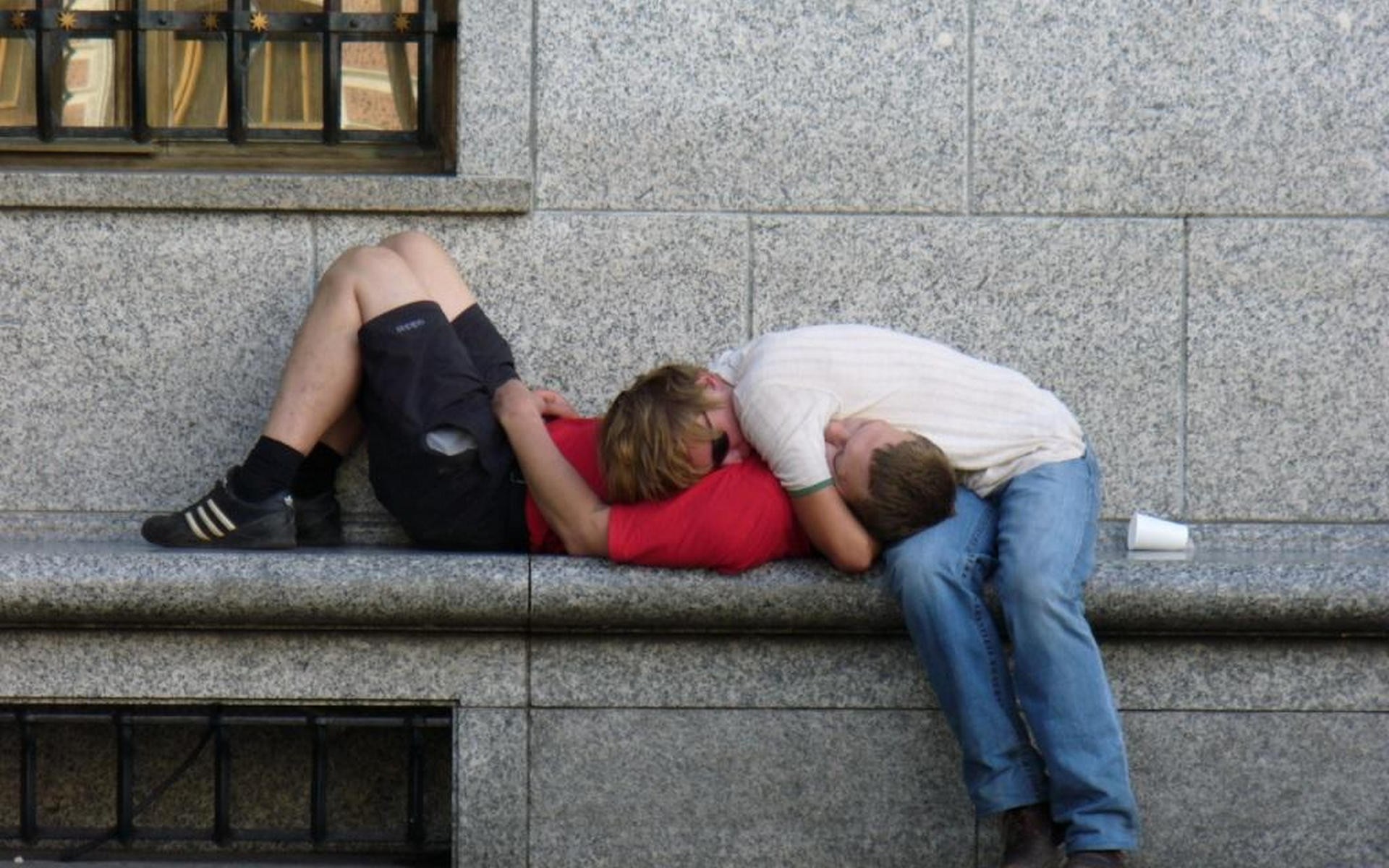 Two people sleeping on a bench