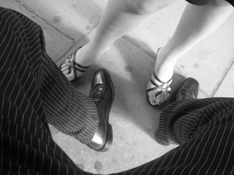 two people standing on pavement
