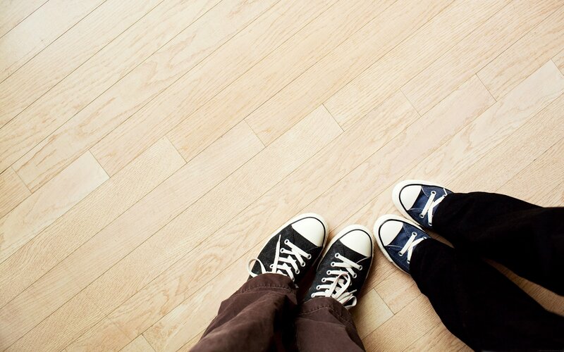 two people standing on wood floor