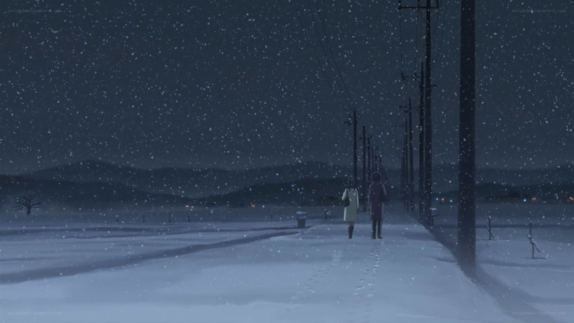 Two people walking in snow at night