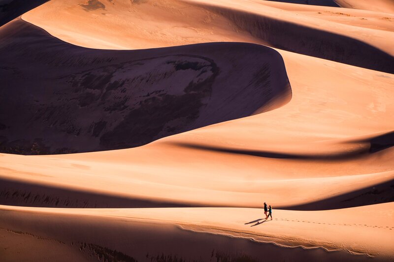 Two People Walking on Dunes