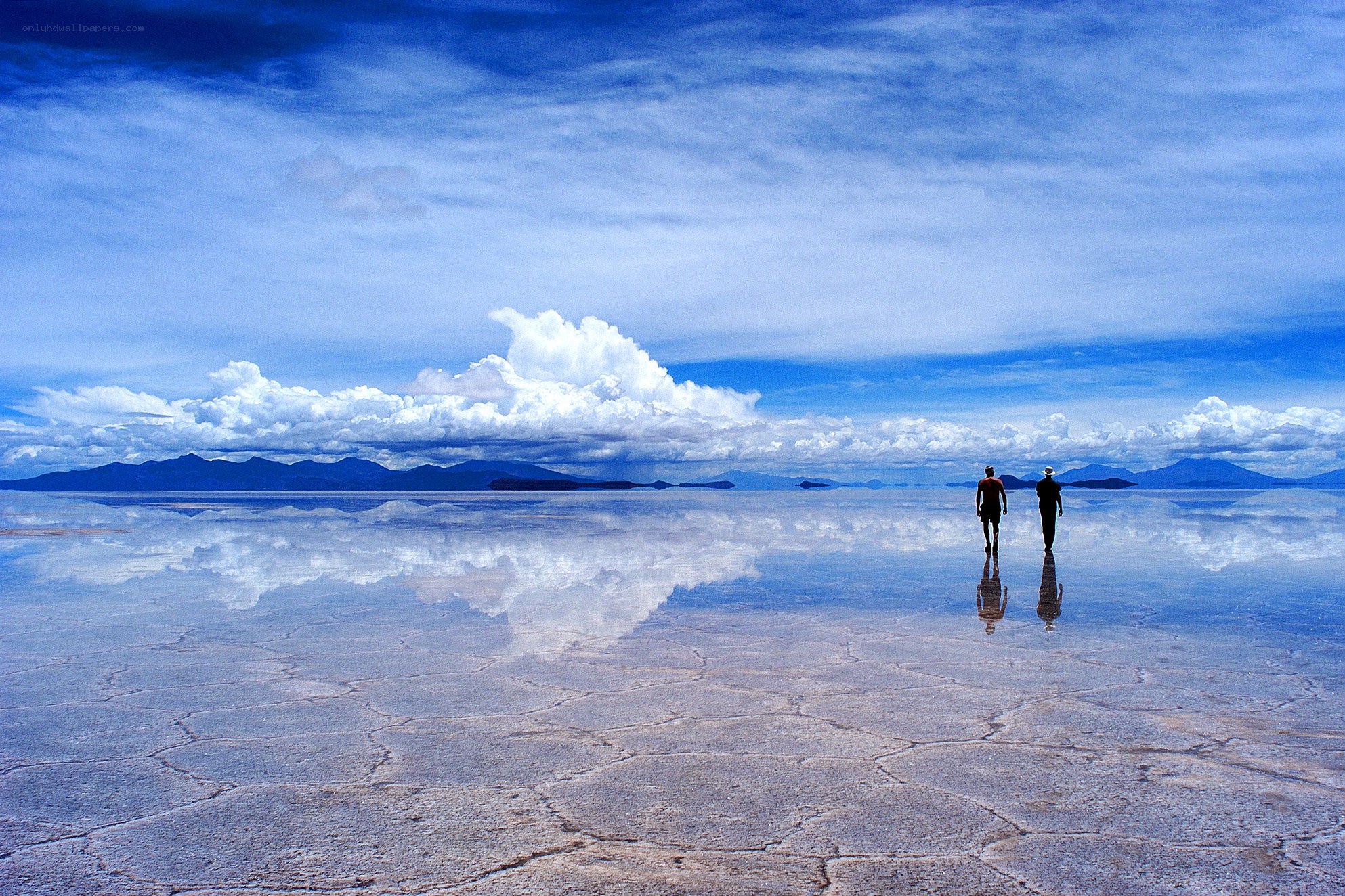 Two people walking on salt flats