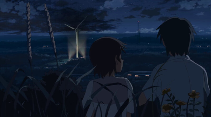 two people watching wind turbine at night