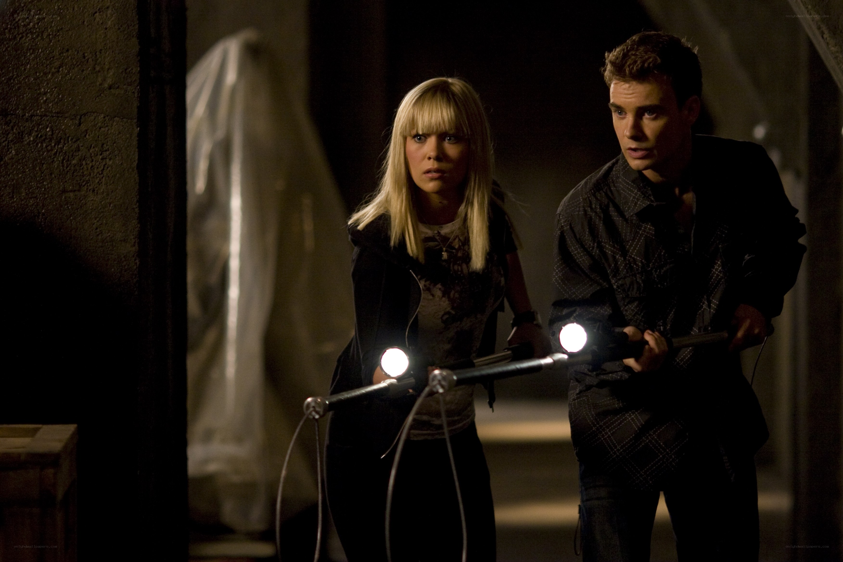 Two people with flashlights in dark room