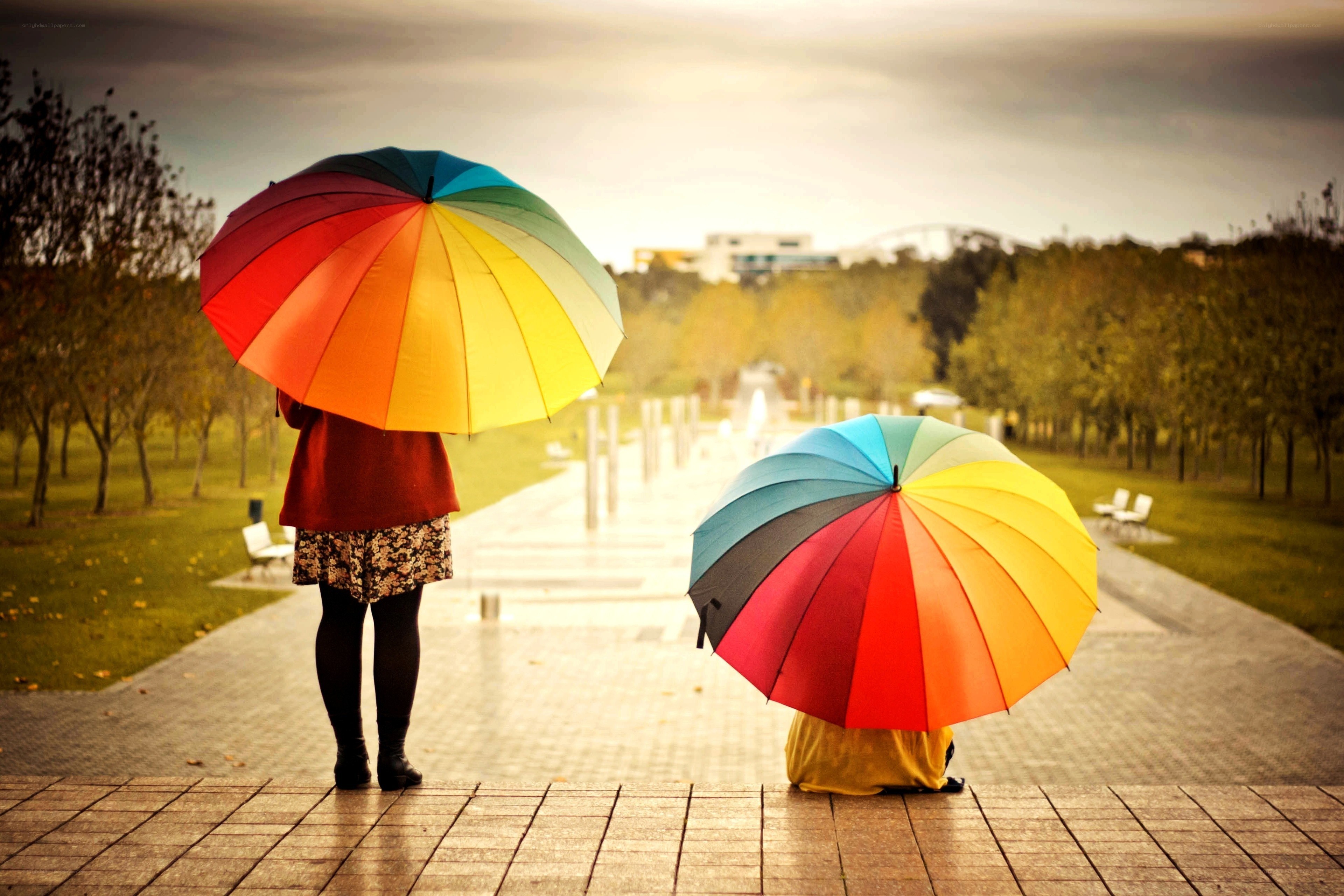 Two people with rainbow umbrellas