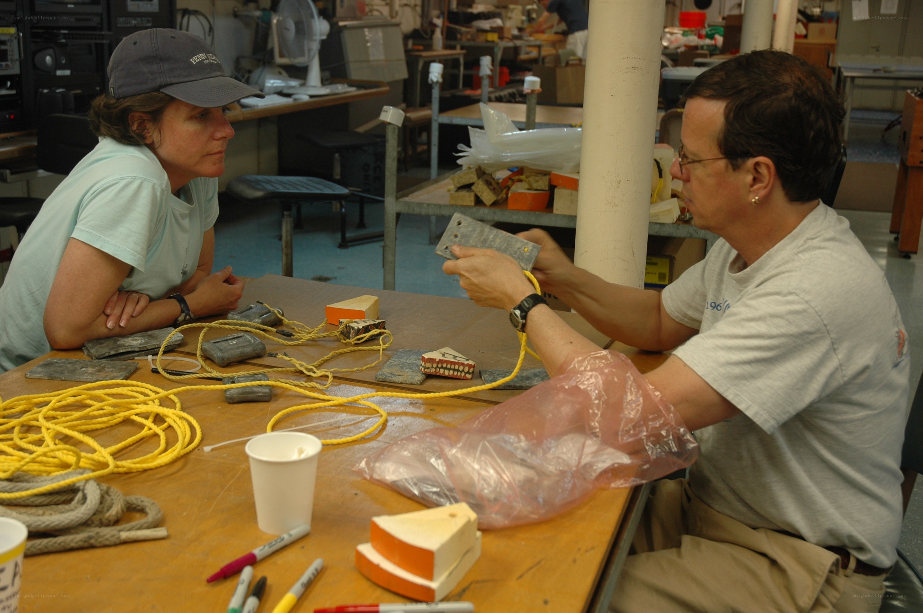 Two people working with ropes and materials