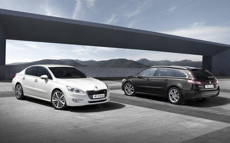 Two Peugeot cars on a paved lot