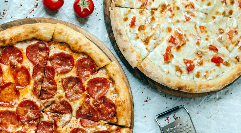 Two Pizzas on Wooden Boards