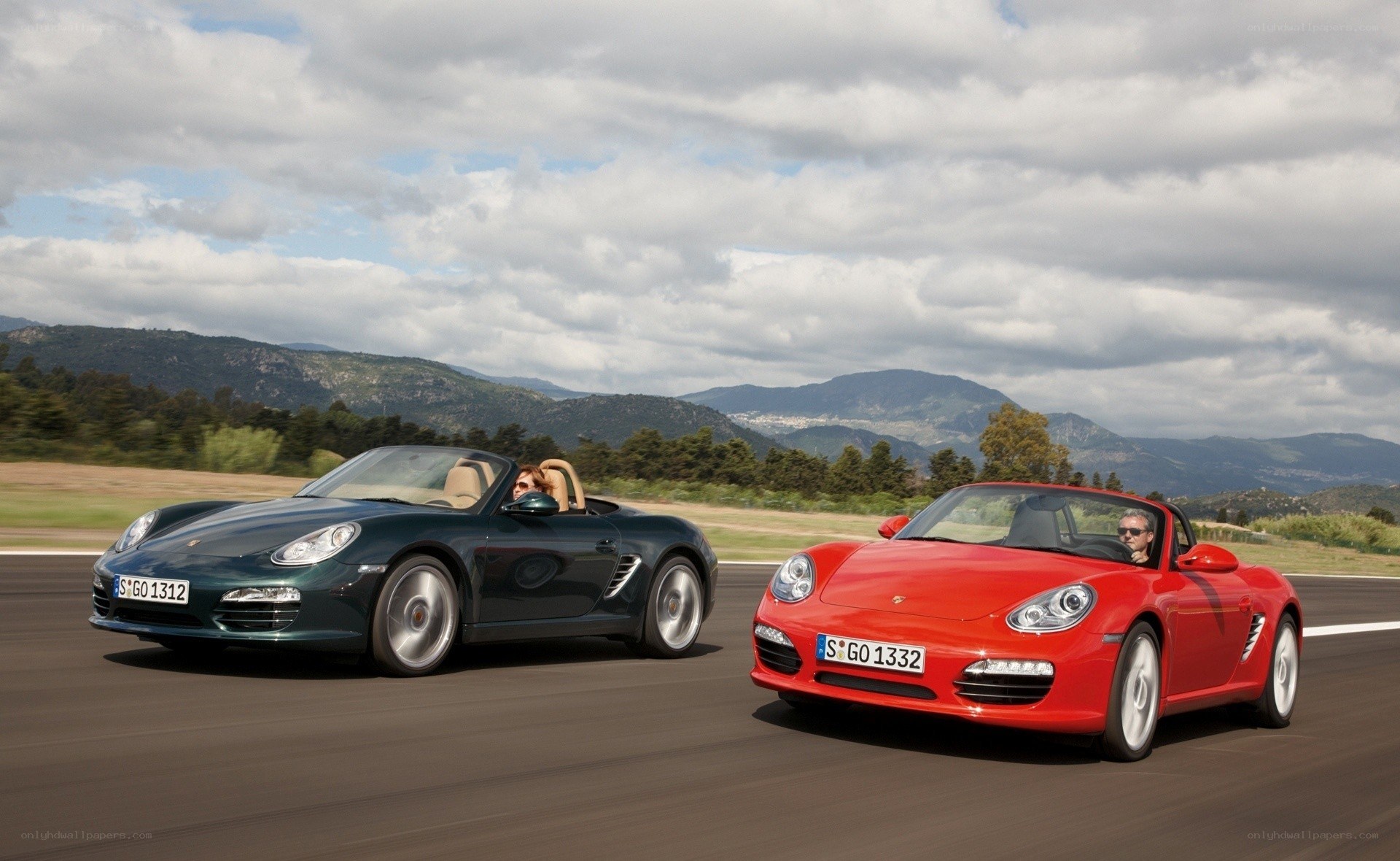 Two Porsche Boxsters on a road