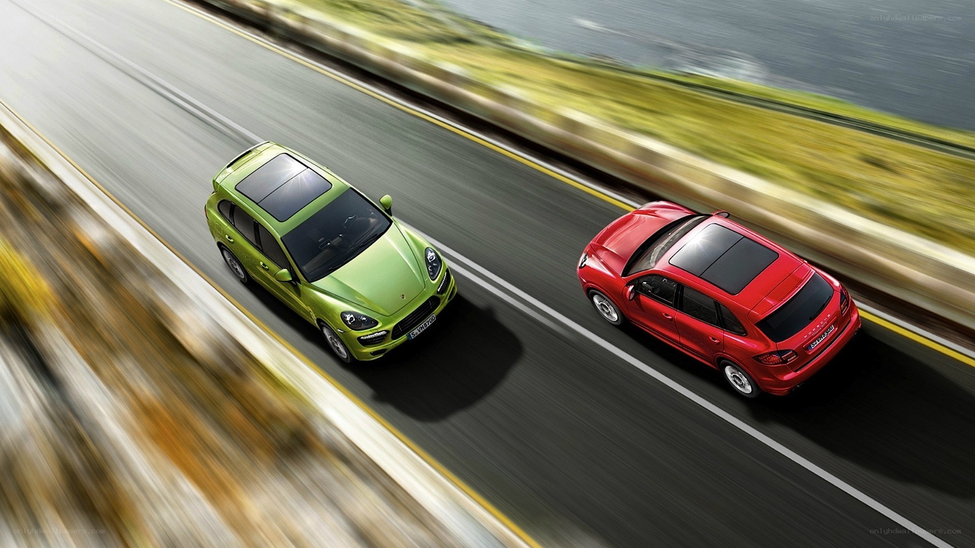 Two Porsche Cayenne SUVs on a road