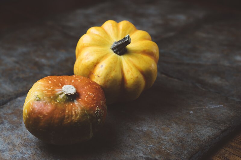 Two pumpkins on a wooden surface