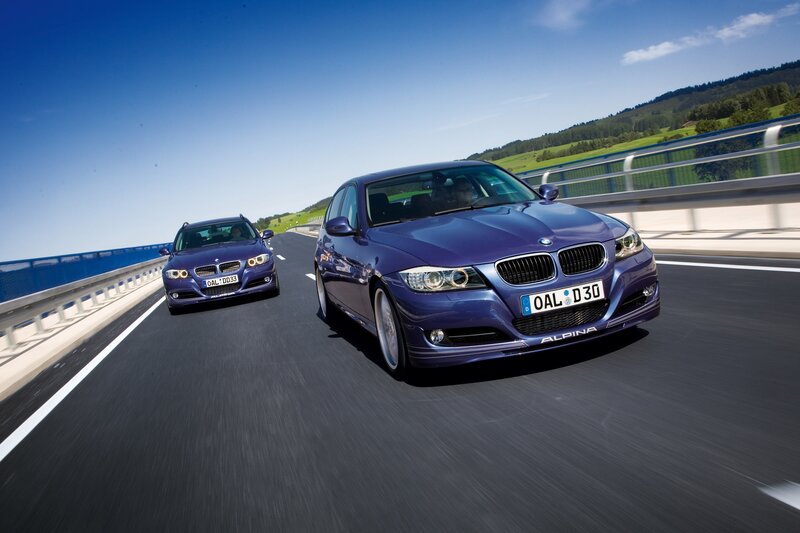Two purple BMW Alpina cars on a bridge
