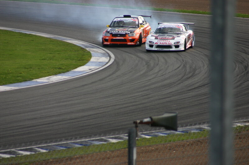 Two race cars drifting on a track