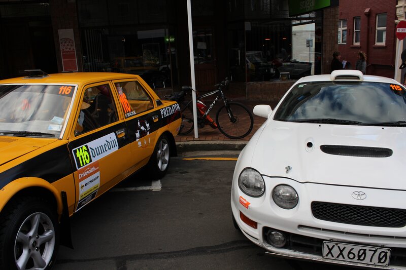 Two race cars parked on street