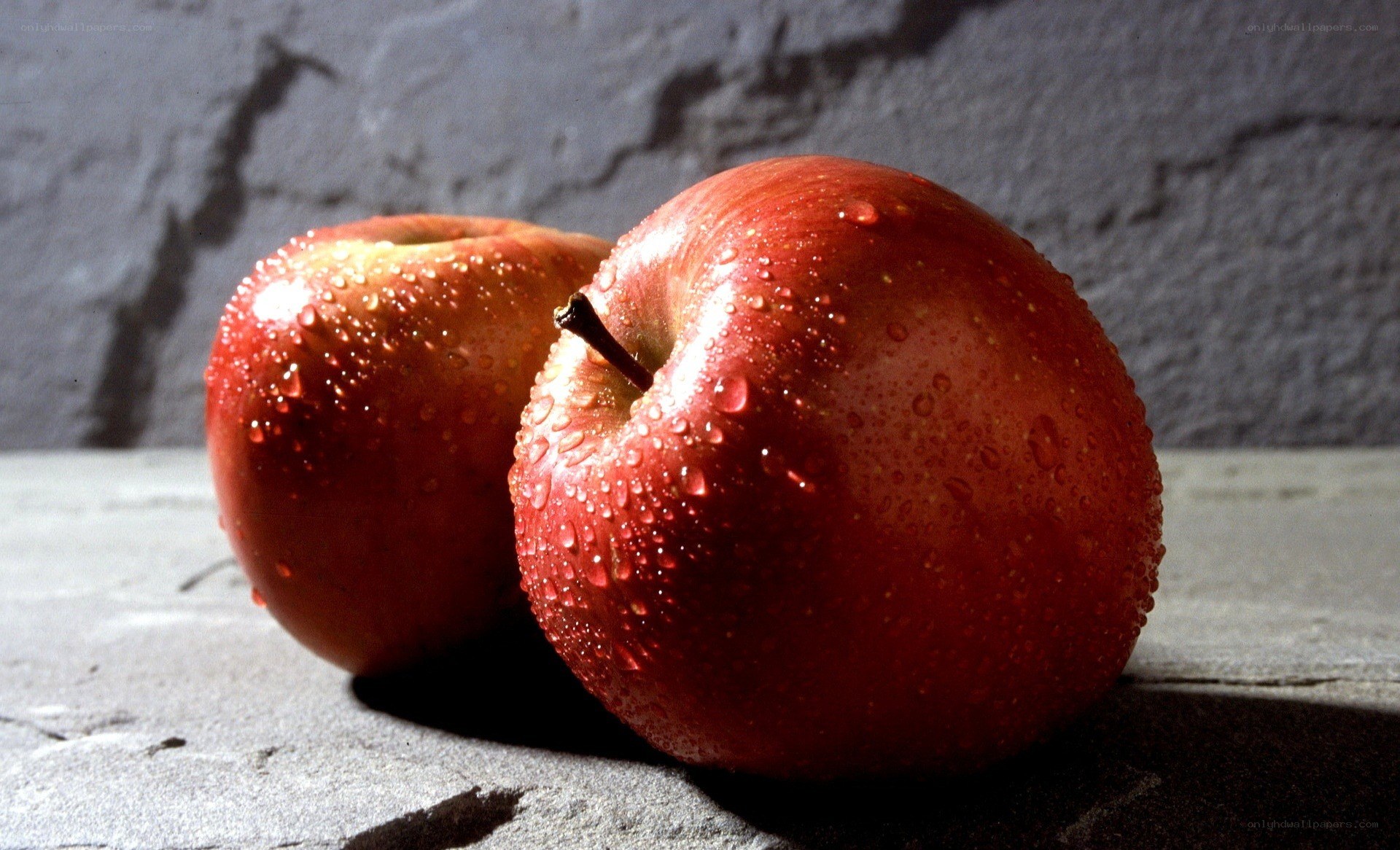Two red apples with water droplets