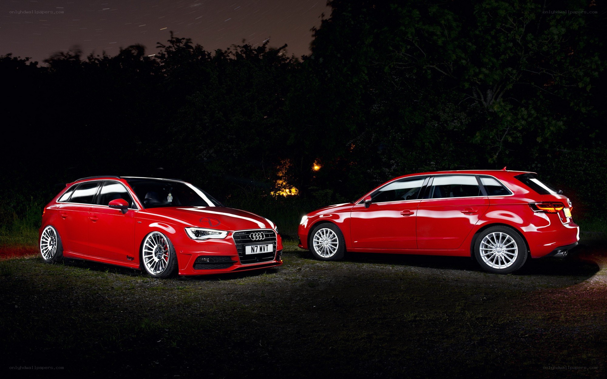 Two red Audi cars at night