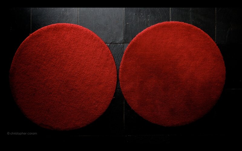 Two red circular rugs