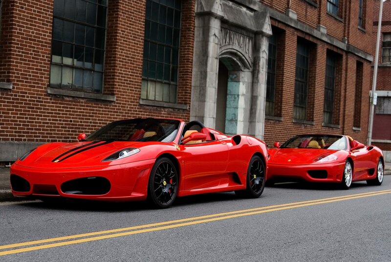 Two red Ferraris on a city street