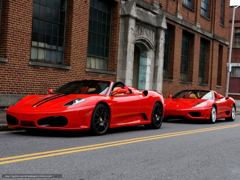 Two red Ferraris on a city street