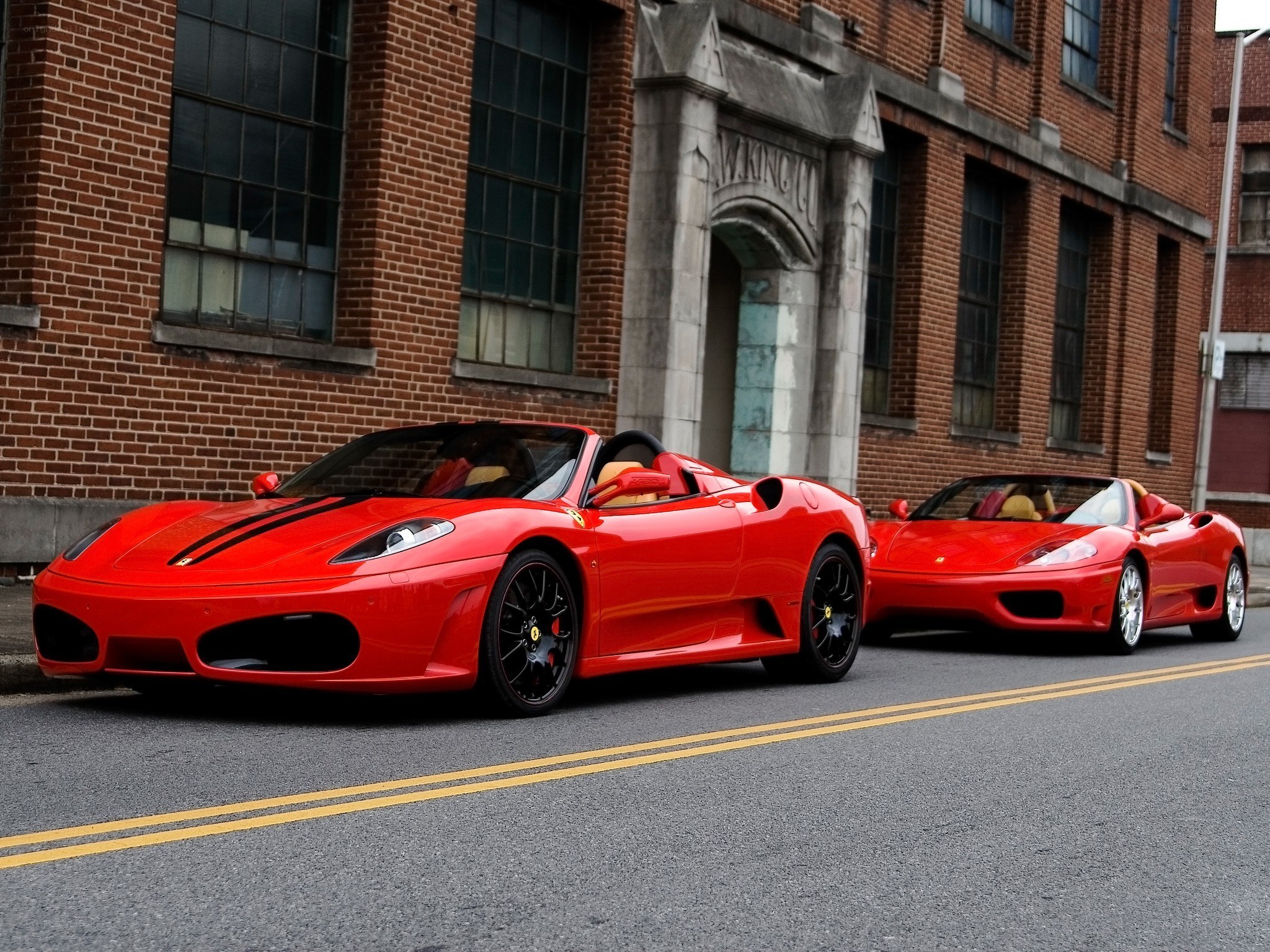 Two red Ferraris on a street