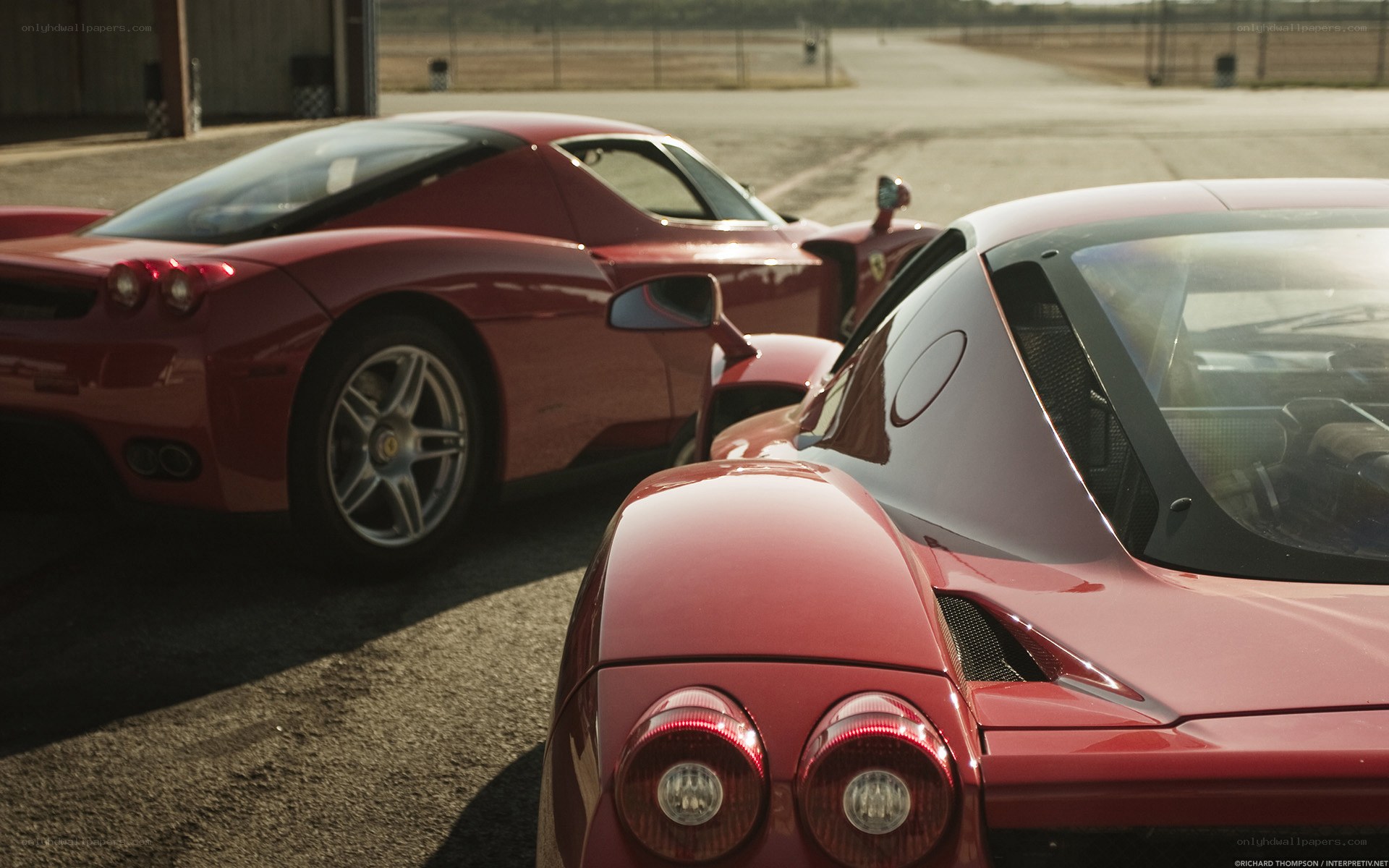 Two red Ferraris parked