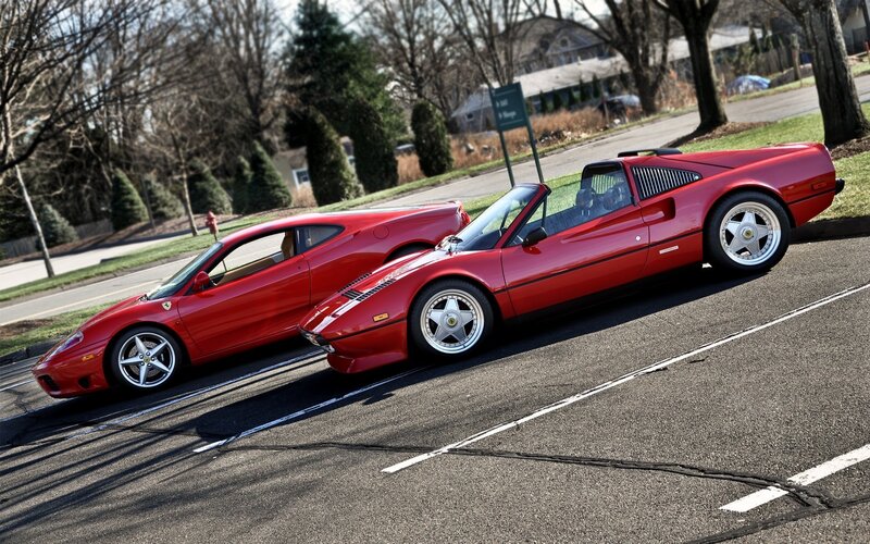 Two red Ferraris parked