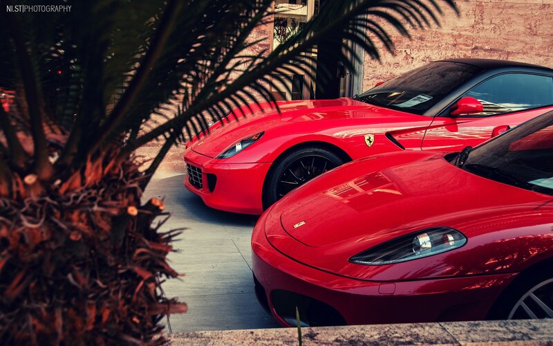 Two red Ferraris parked