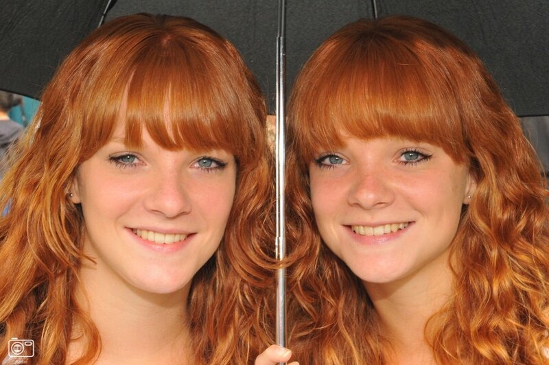 Two red-haired women under an umbrella