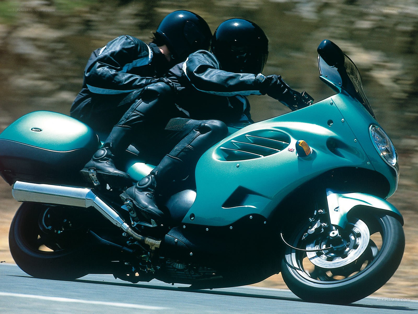 Two riders on a teal motorcycle