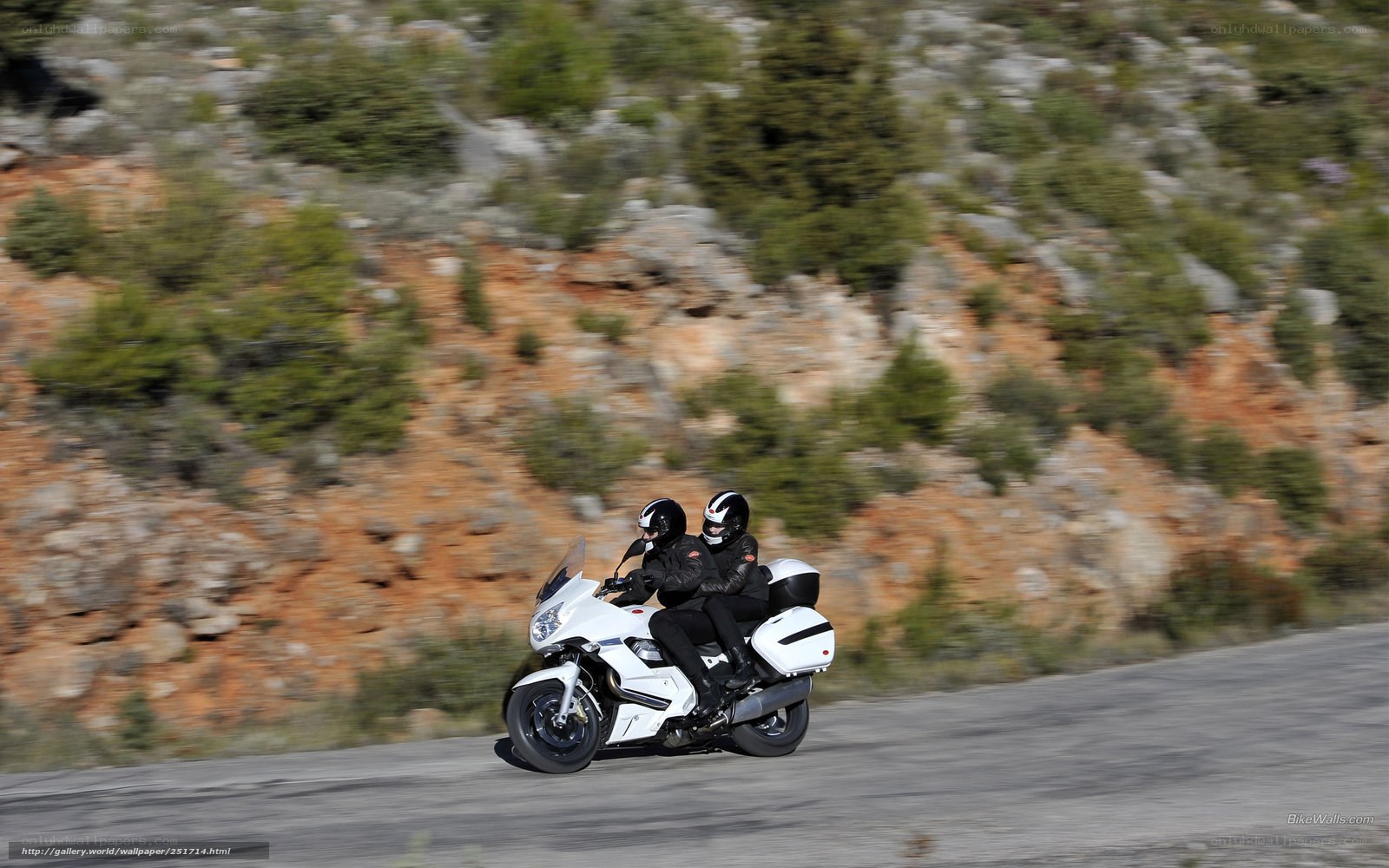 Two riders on a white motorcycle