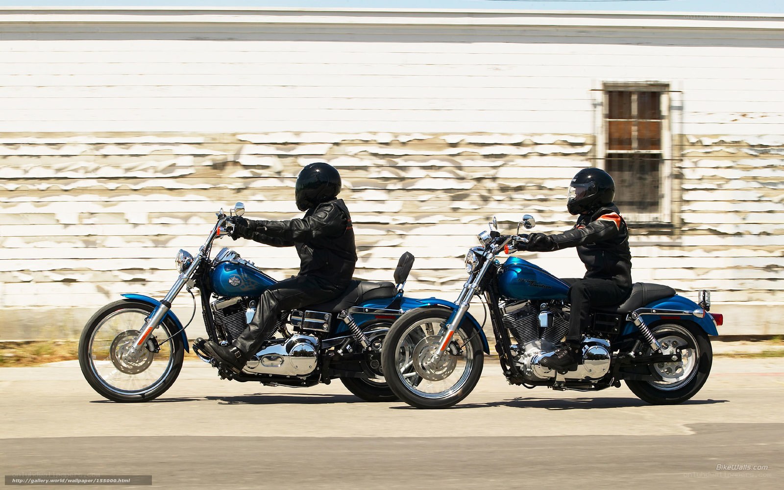 Two riders on blue motorcycles