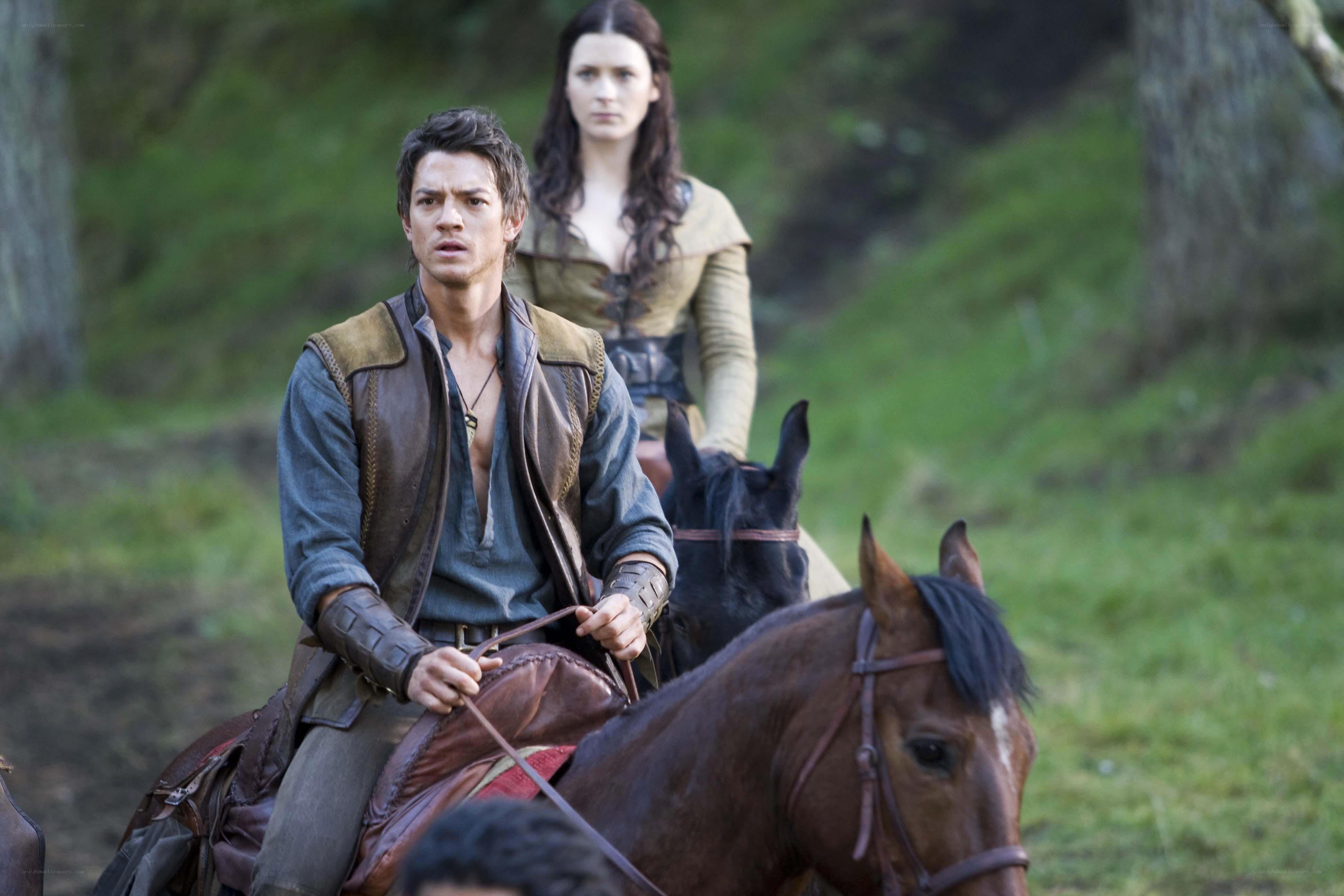 Two riders on horses in a forest