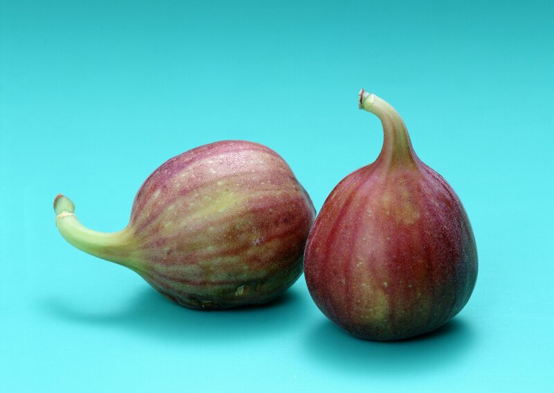 Two ripe figs on blue