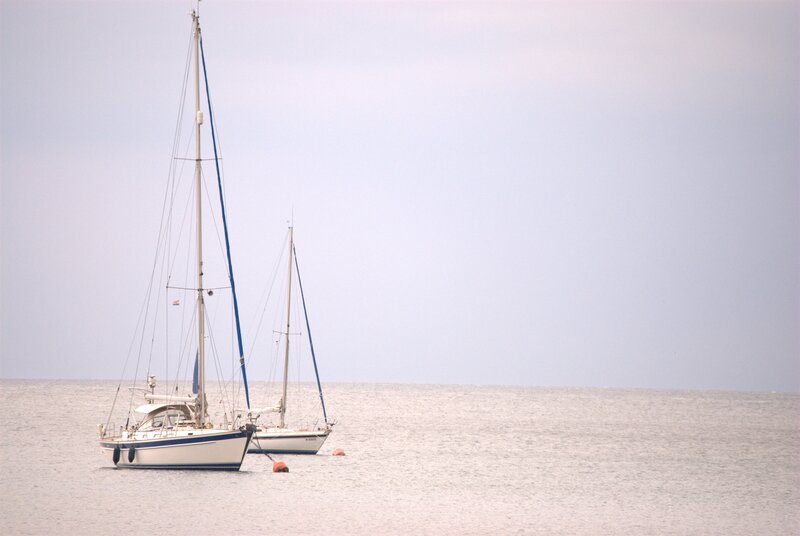 Two sailboats on calm water