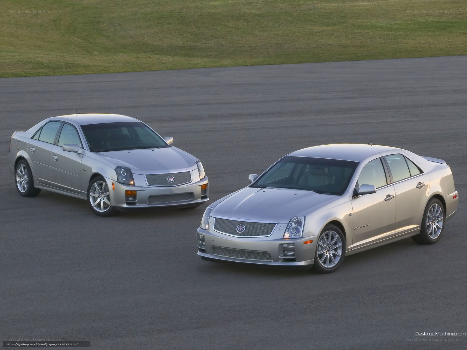 Two silver Cadillac sedans on track