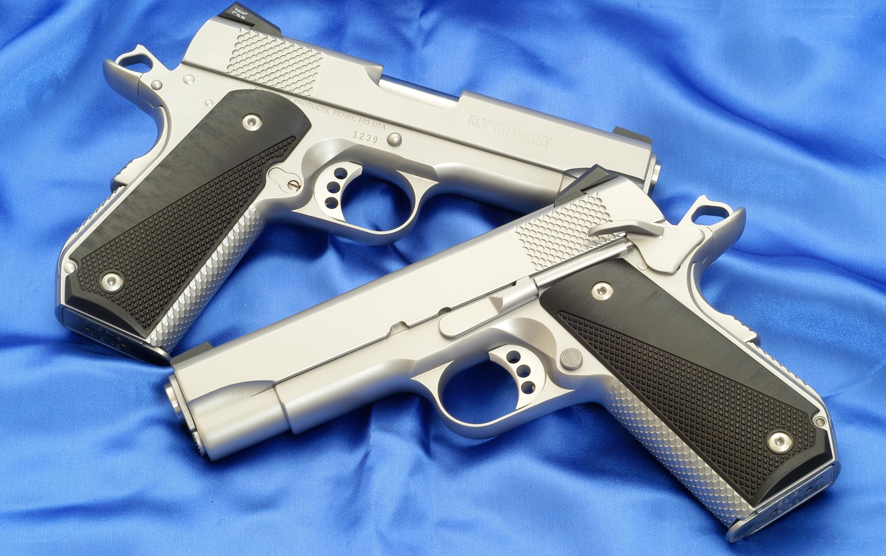 Two silver handguns on blue cloth