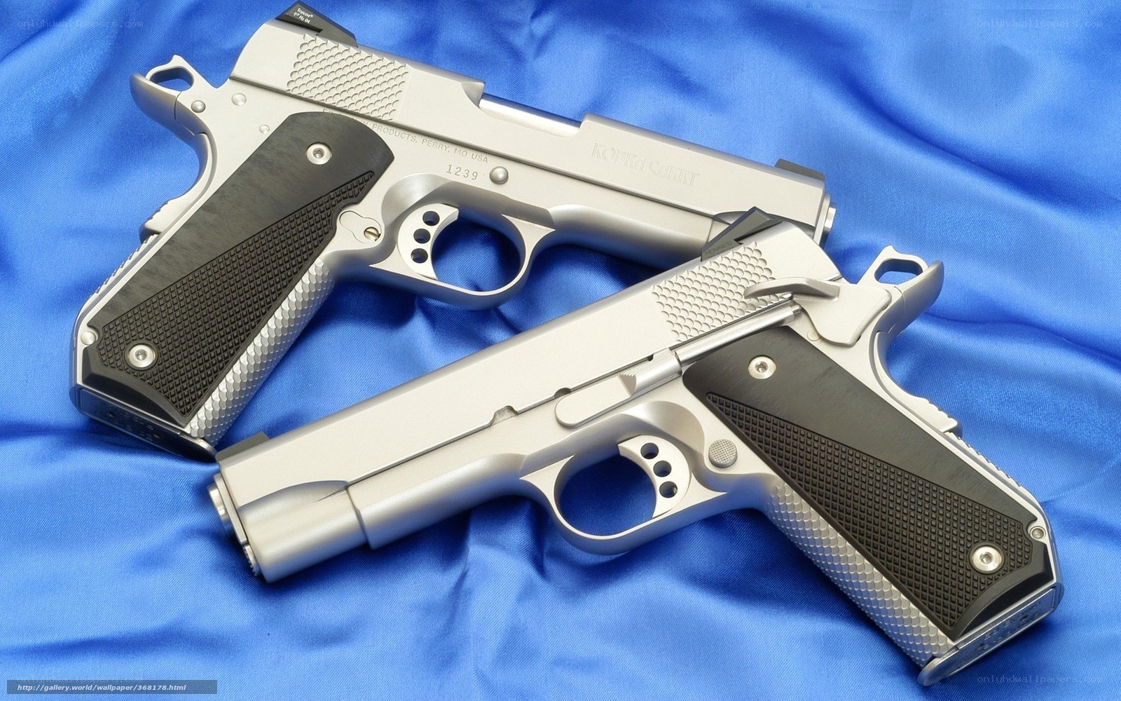 Two silver handguns on blue cloth