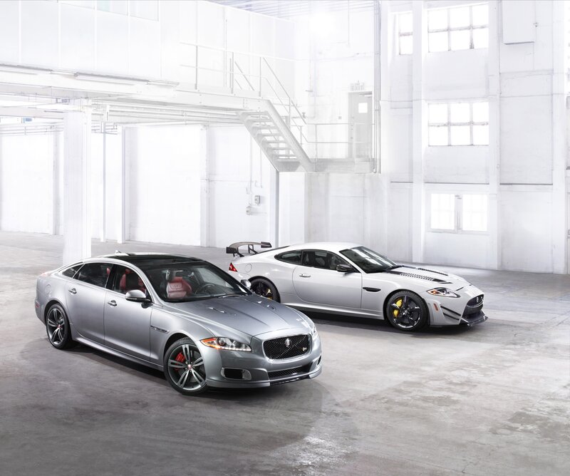 Two silver Jaguar cars in a warehouse