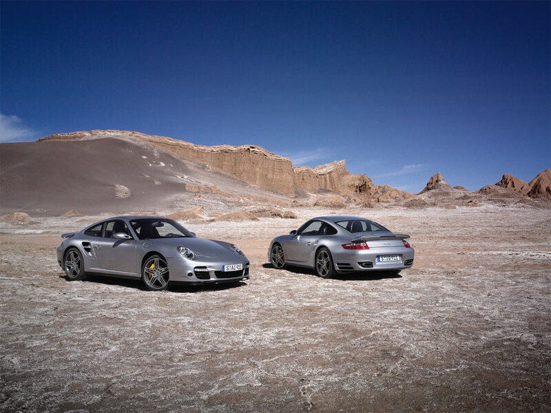 Two silver Porsche cars in desert