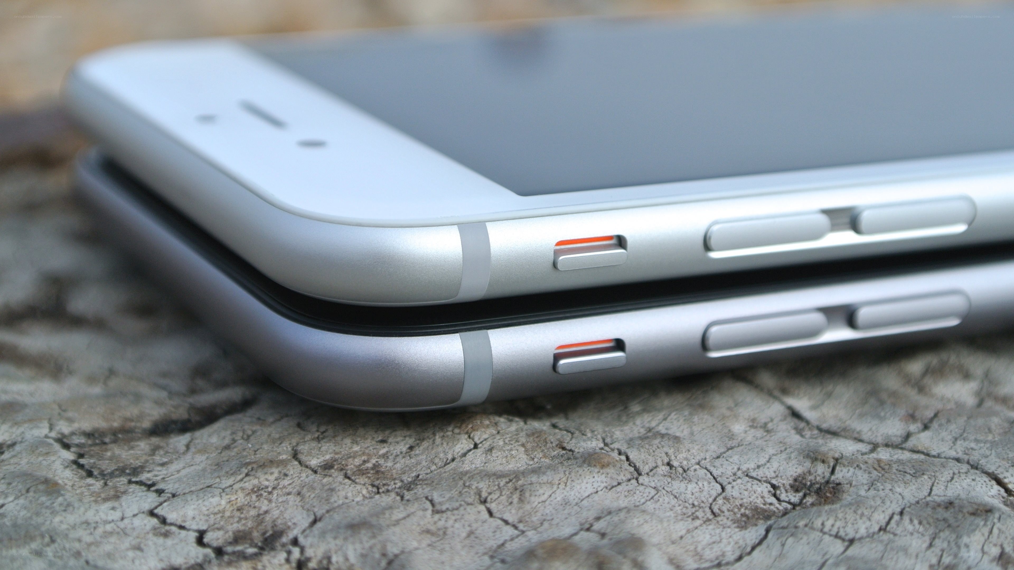 Two smartphones stacked on wood