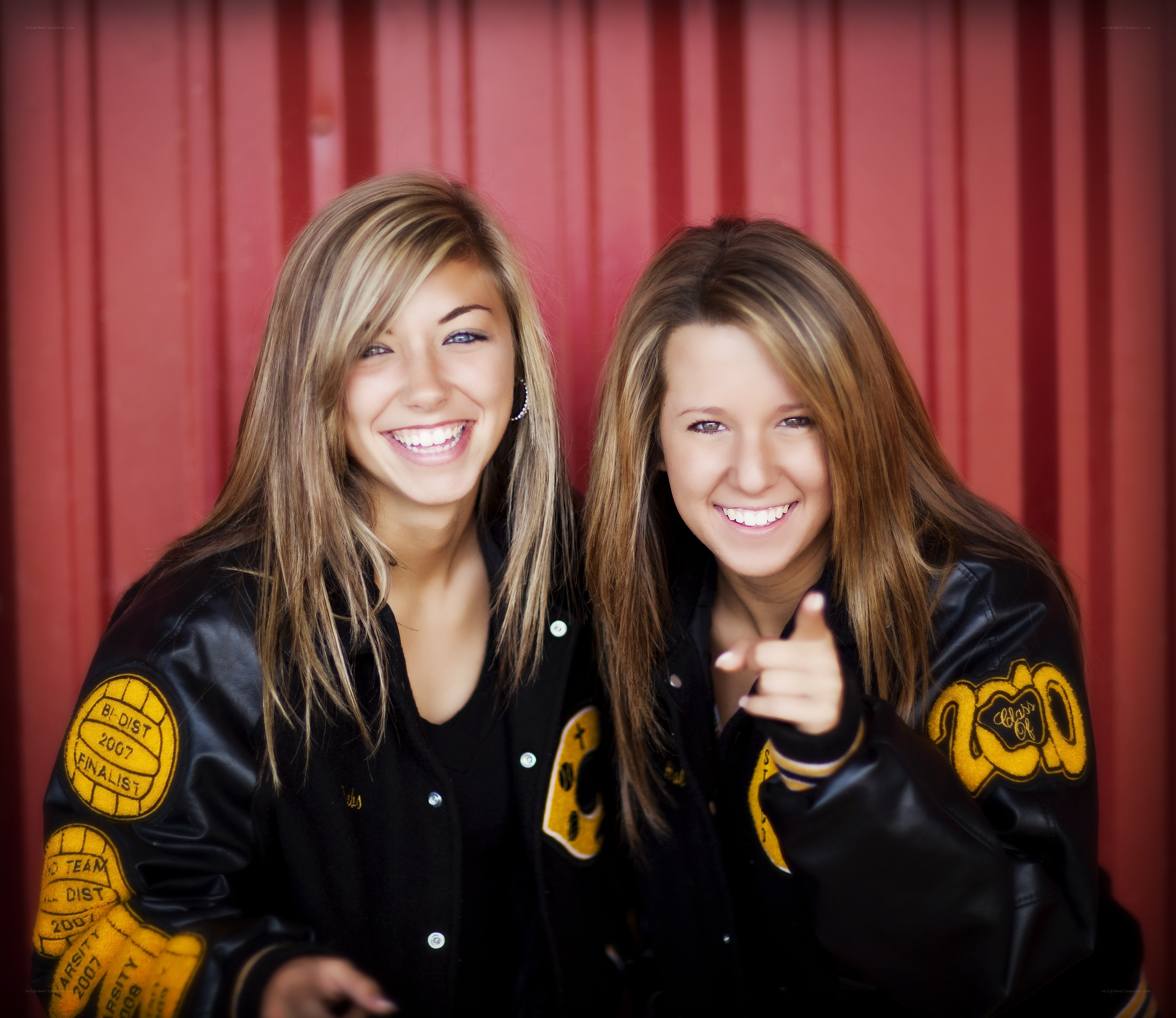 Two smiling girls in letterman jackets