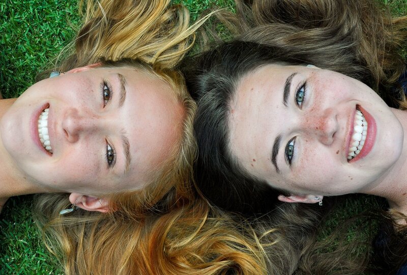 two smiling girls on grass