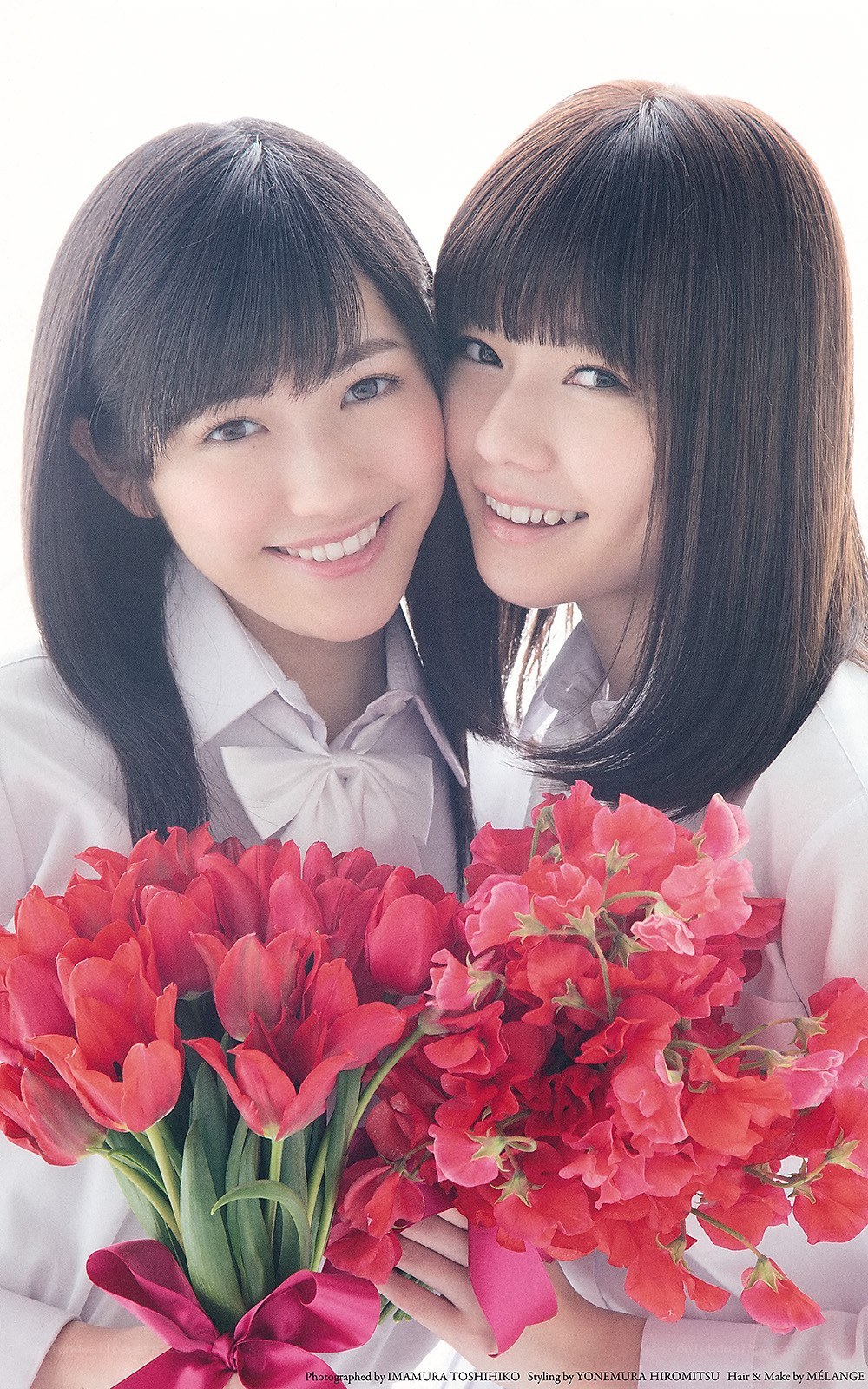 Two smiling girls with flowers