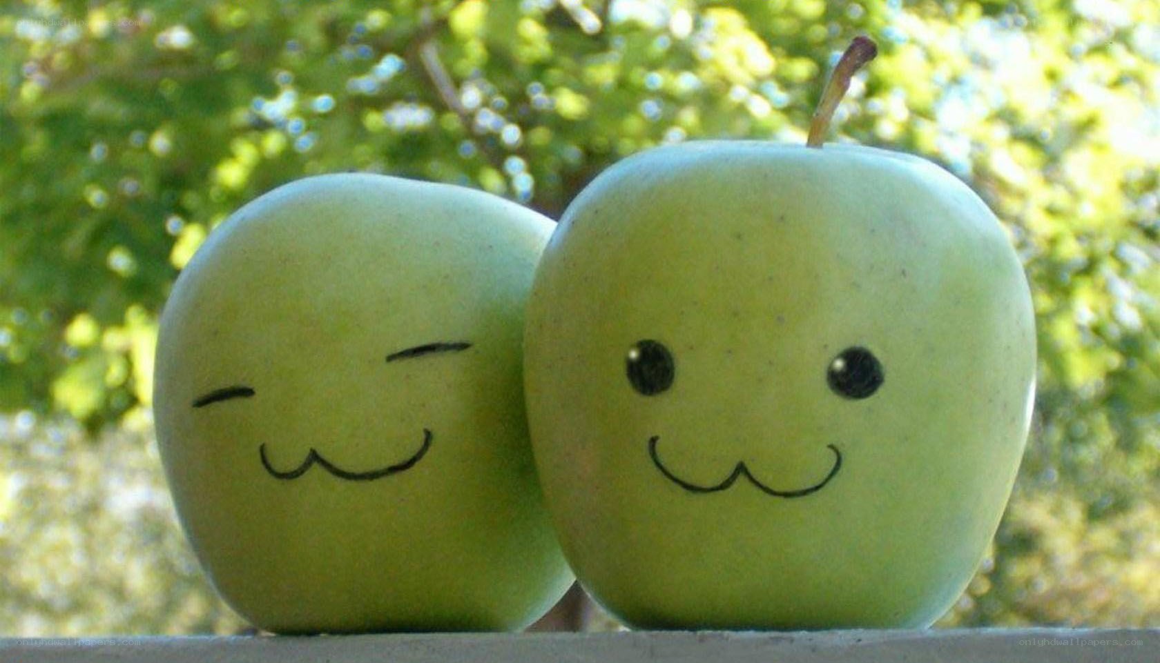 Two smiling green apples