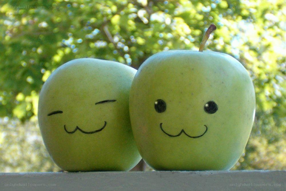 Two smiling green apples