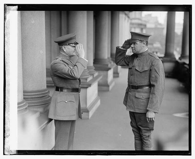 Two soldiers saluting each other