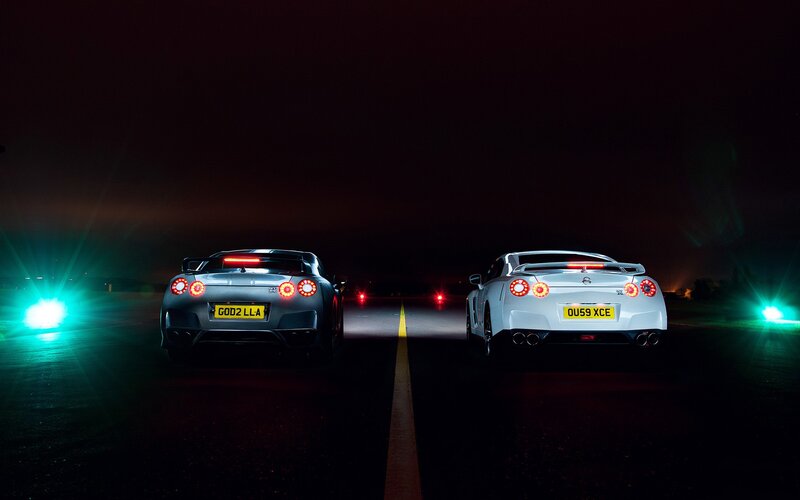 Two sports cars at night