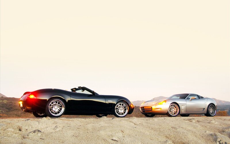 Two sports cars on a hillside