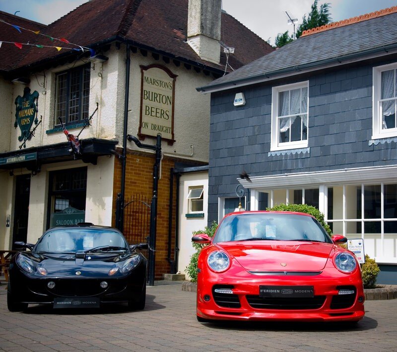 Two sports cars outside a pub